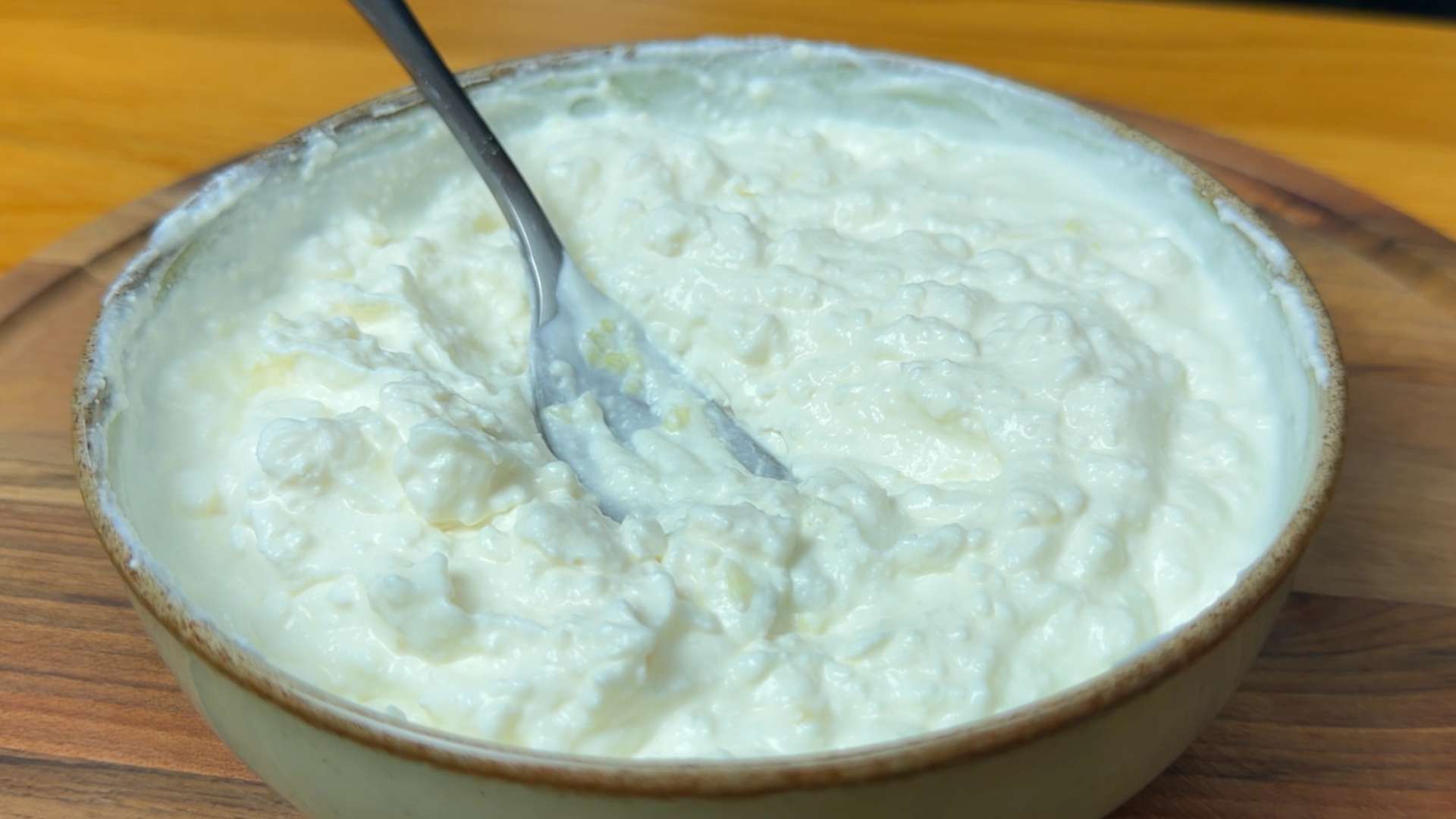 Creamy whipped feta and yogurt sauce served in a ceramic bowl with a metal spoon.
