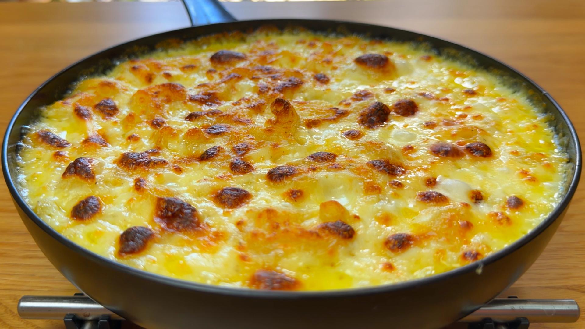 Close-up of creamy mac and cheese in a pan topped with crispy bacon