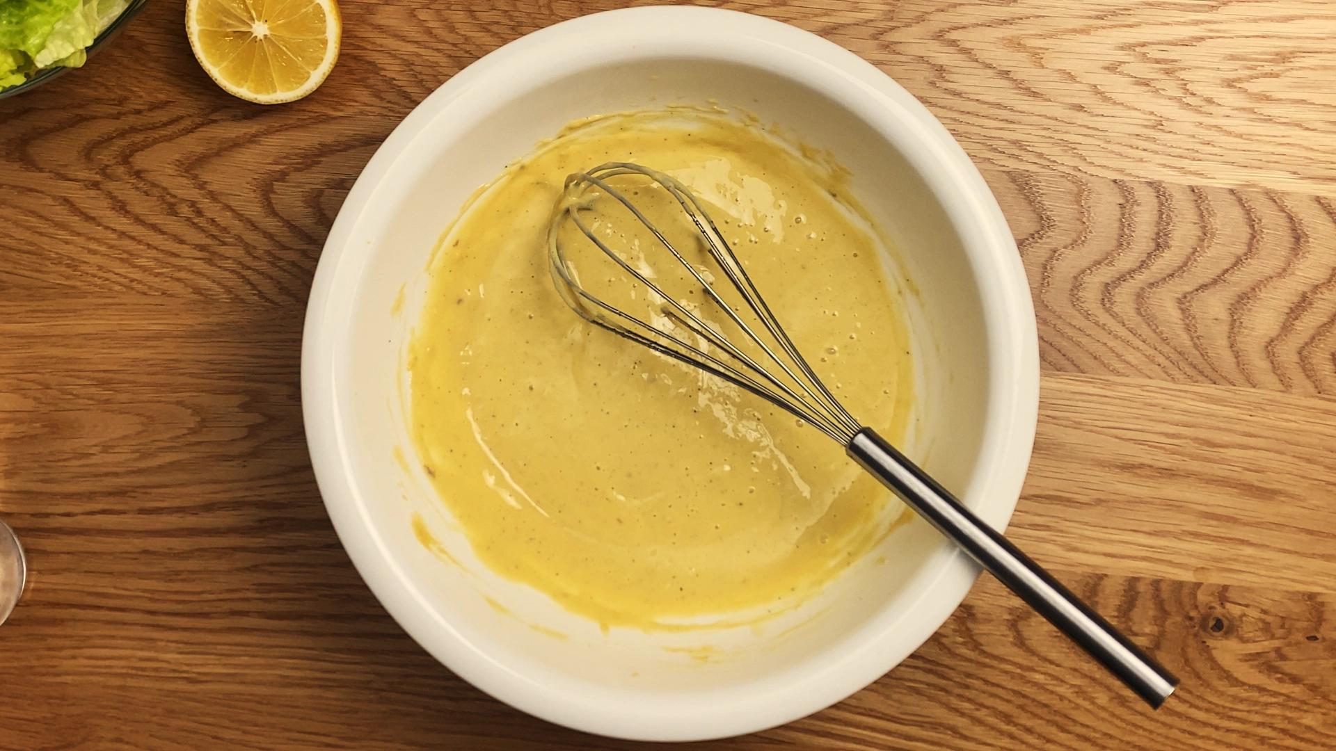 Creamy Caesar dressing with a smooth texture, made from garlic, anchovies, parmesan, and olive oil.