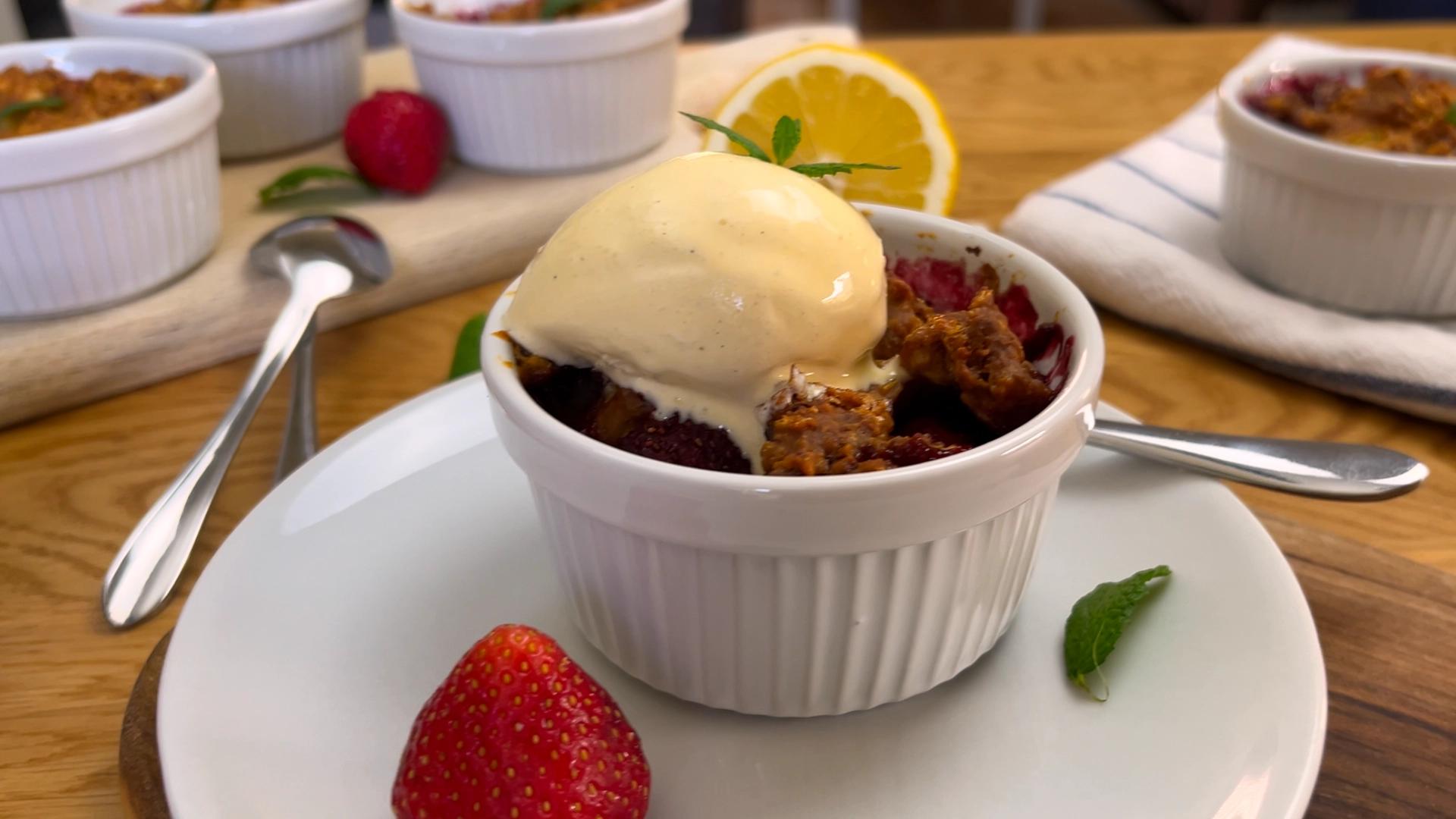 Fresh mixed berry cobbler with juicy strawberries, blueberries, raspberries, and blackberries baked under a golden buttery biscuit topping in a rustic baking dish.
